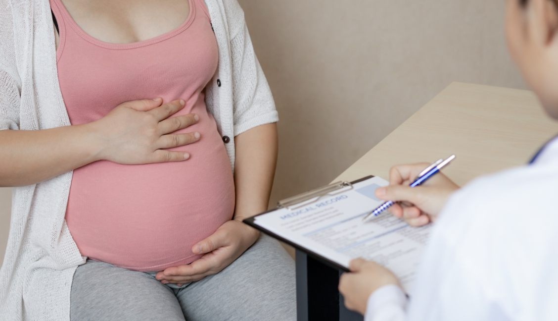 A pregnant woman discusses prenatal care with her doctor